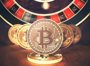 Das Bild zeigt das Bitcoin Logo vor einem Roulettekessel.